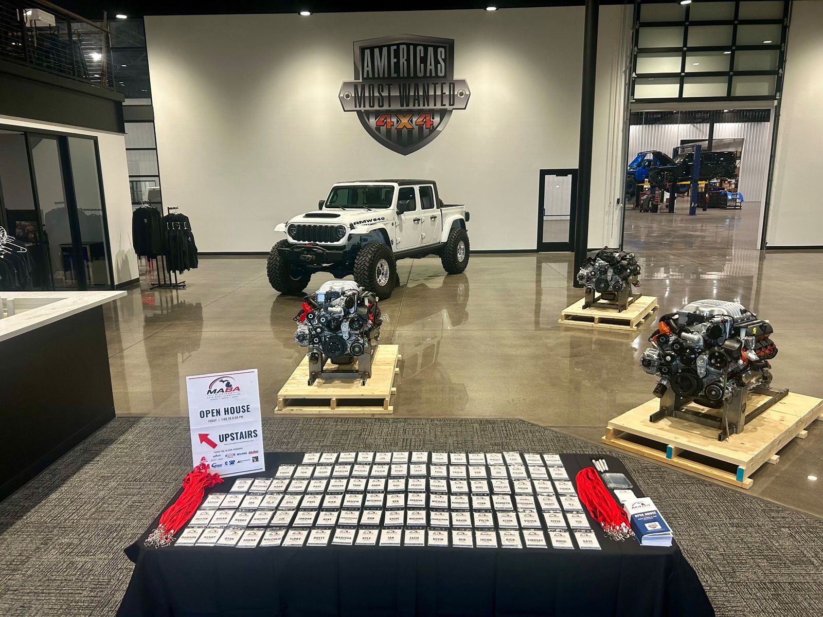 MABA Open House check-in table with rows of name badges in front of the America's Most Wanted 4x4 showroom